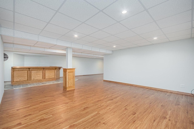 basement featuring light hardwood / wood-style flooring and a drop ceiling