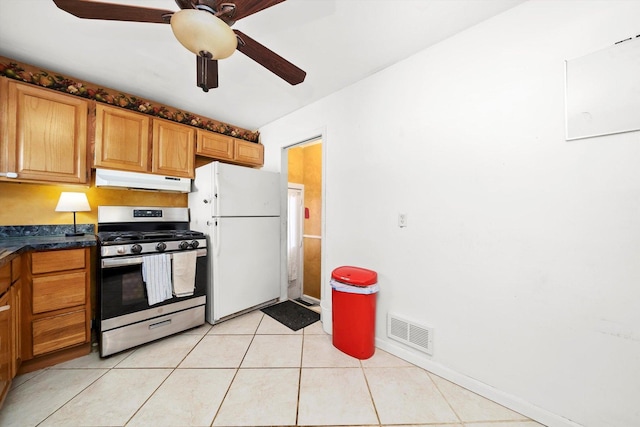 kitchen with ceiling fan, light tile patterned floors, stainless steel gas range, and white refrigerator