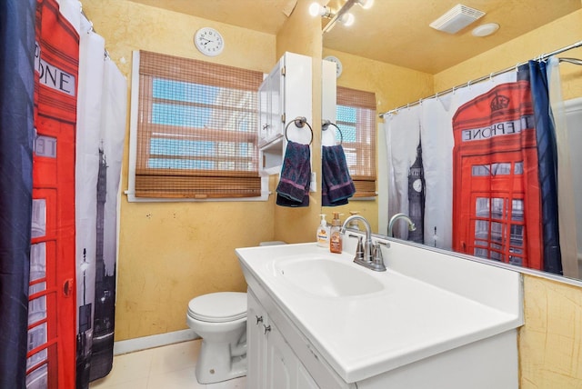 bathroom featuring toilet, vanity, walk in shower, and tile patterned flooring