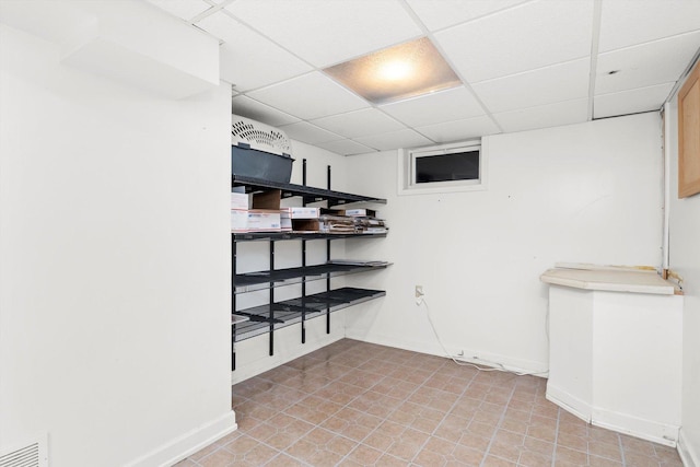 interior space featuring a drop ceiling and light tile patterned floors