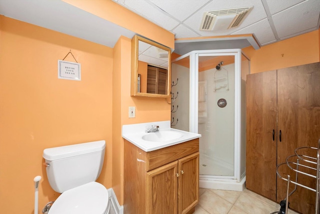 bathroom with a drop ceiling, an enclosed shower, vanity, and tile patterned flooring