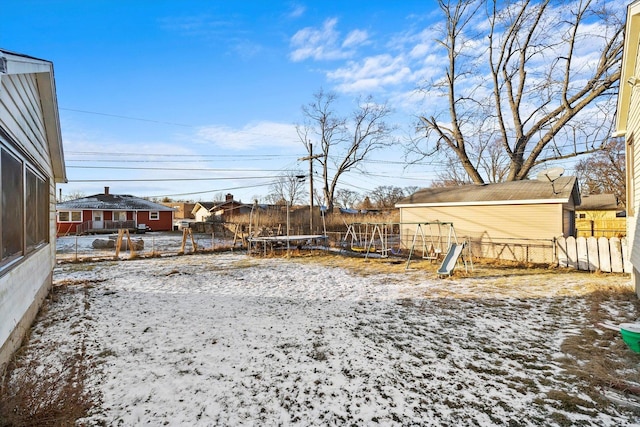 yard layered in snow featuring a trampoline