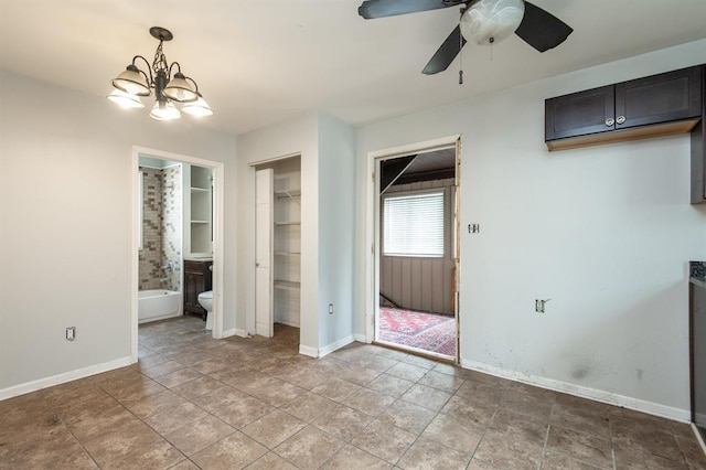 unfurnished bedroom featuring connected bathroom, a closet, and ceiling fan with notable chandelier