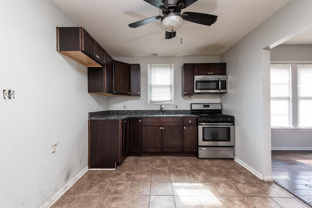 kitchen with sink, ceiling fan, light tile patterned floors, dark brown cabinets, and stainless steel appliances