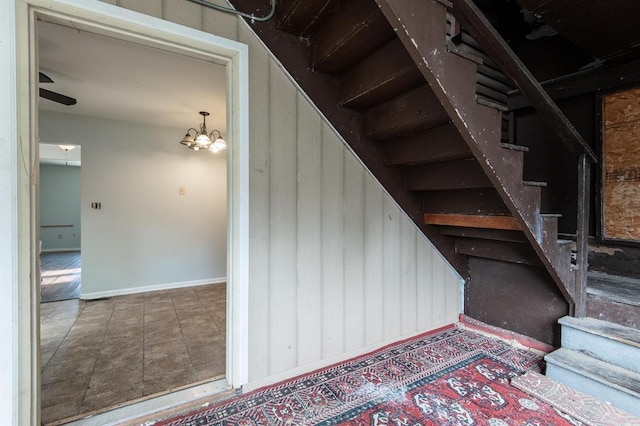 stairway with a notable chandelier