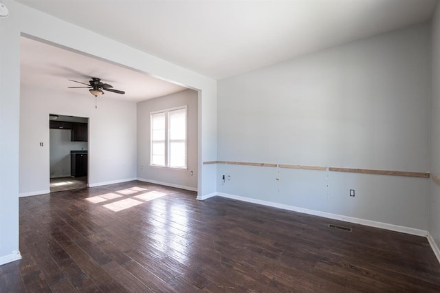 empty room featuring dark hardwood / wood-style flooring and ceiling fan