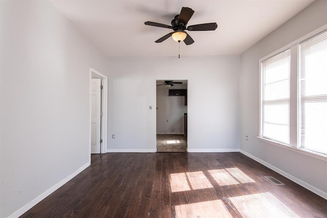 empty room with ceiling fan and dark hardwood / wood-style floors