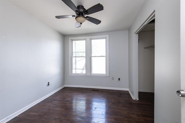 unfurnished bedroom featuring ceiling fan, dark wood-type flooring, and a closet