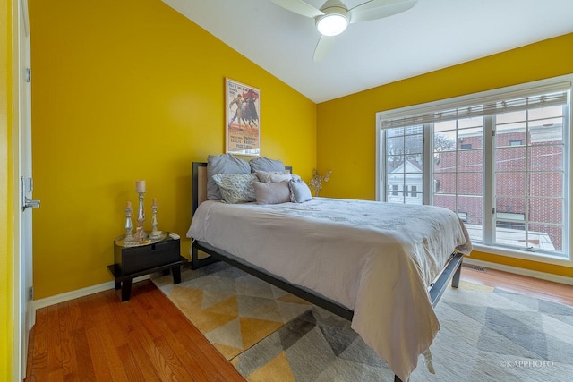 bedroom featuring ceiling fan, hardwood / wood-style floors, and vaulted ceiling