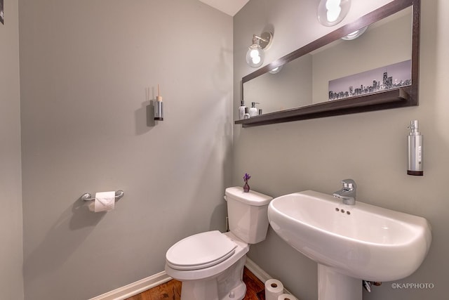 bathroom with toilet, hardwood / wood-style floors, and sink