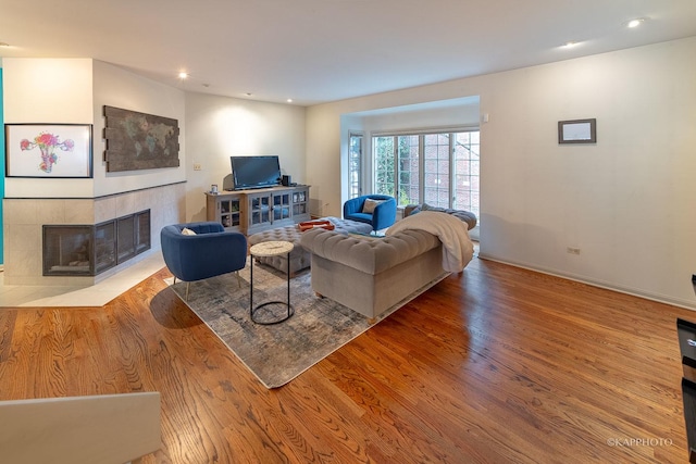 living room featuring light hardwood / wood-style floors and a tile fireplace