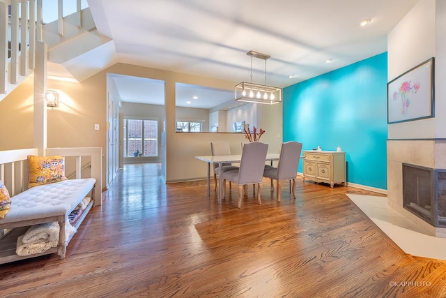 dining area featuring a tiled fireplace and hardwood / wood-style floors