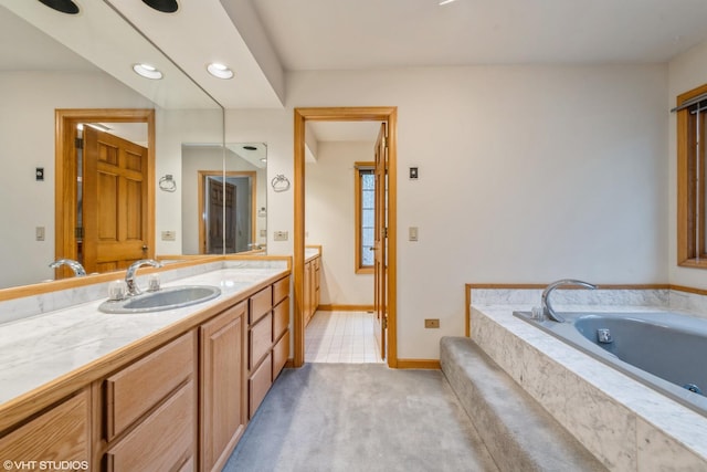 bathroom featuring tiled bath and vanity