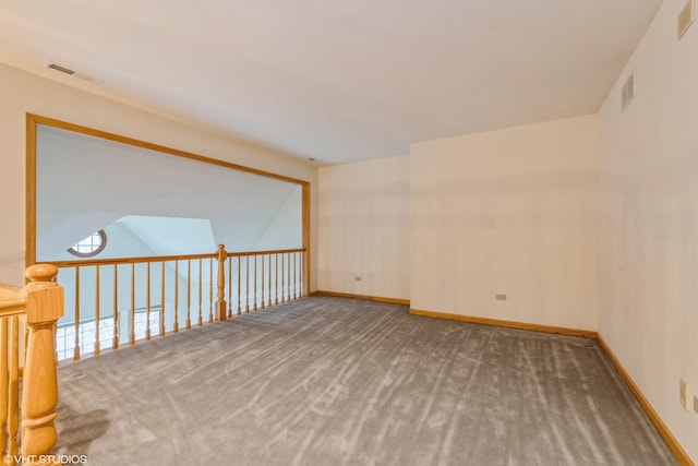 carpeted spare room featuring lofted ceiling