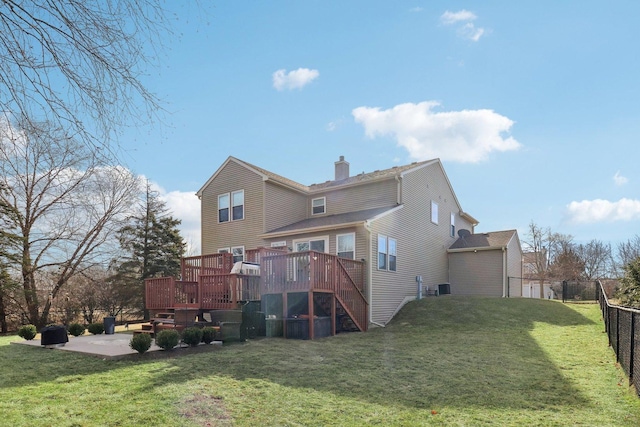 back of property with a patio area, a lawn, and a deck