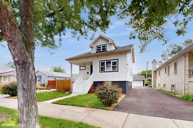 view of front of home with an outbuilding, a front lawn, and a garage