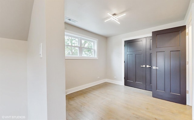 unfurnished bedroom with light hardwood / wood-style floors and a closet