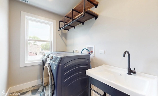 clothes washing area with washing machine and dryer and sink