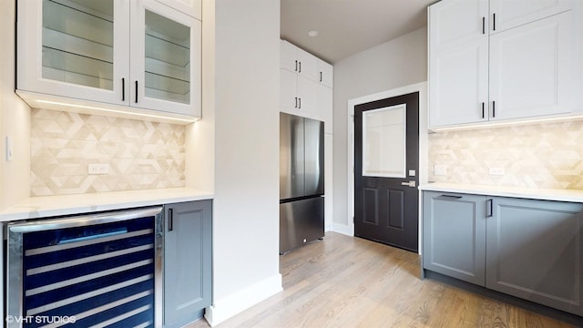 kitchen with white cabinets, stainless steel refrigerator, gray cabinetry, and beverage cooler