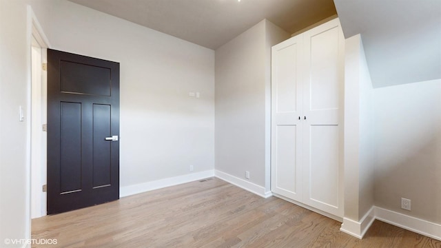 unfurnished bedroom featuring a closet and light hardwood / wood-style flooring