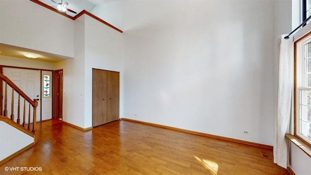 unfurnished living room with a towering ceiling and hardwood / wood-style flooring