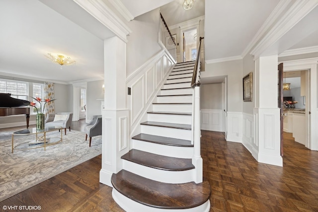 staircase with ornate columns and ornamental molding