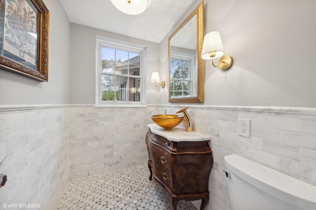 bathroom with vanity, tile walls, and toilet