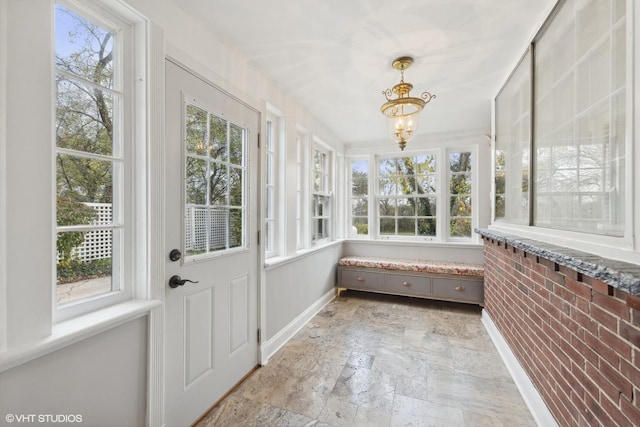 sunroom / solarium with a notable chandelier and a wealth of natural light