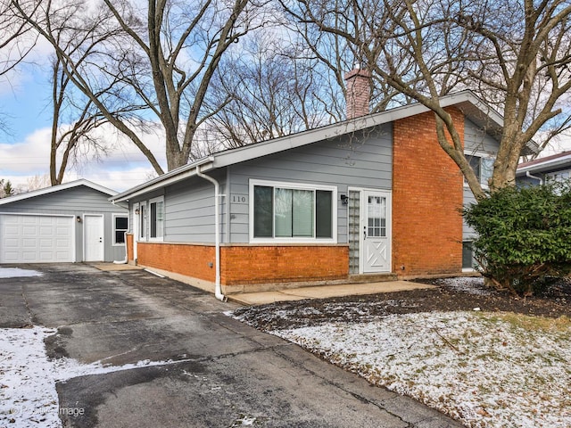 view of front of home with a garage and an outdoor structure