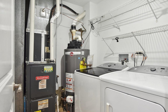 laundry area with washer and dryer, gas water heater, and heating unit