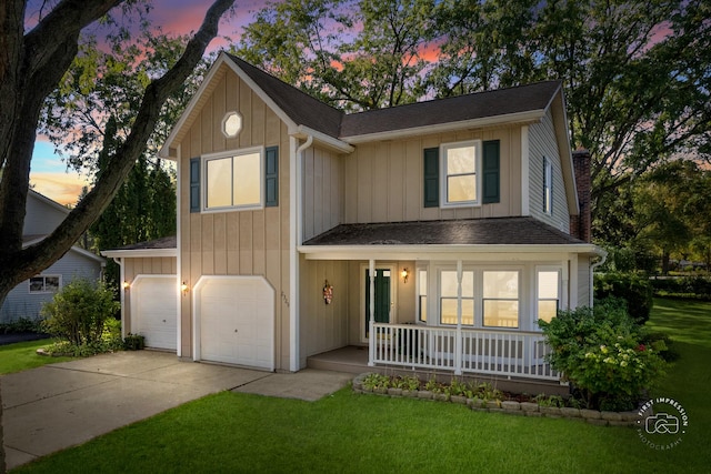 view of front of home with covered porch, a garage, and a lawn