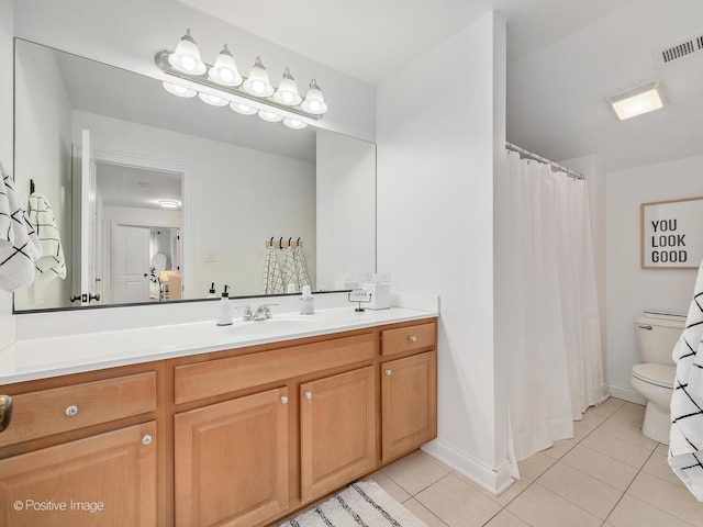 bathroom with toilet, vanity, and tile patterned floors