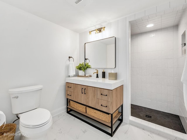 bathroom with tiled shower, vanity, and toilet