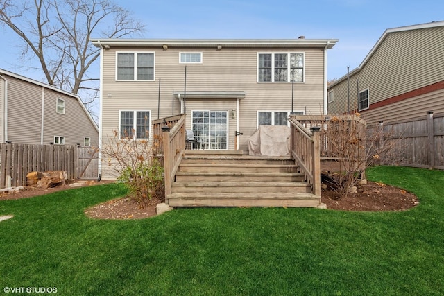 rear view of house featuring a lawn and a wooden deck