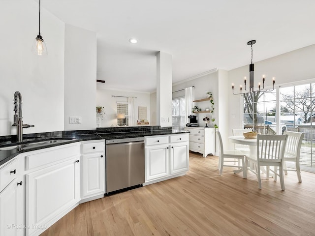 kitchen featuring pendant lighting, sink, stainless steel dishwasher, white cabinetry, and a chandelier