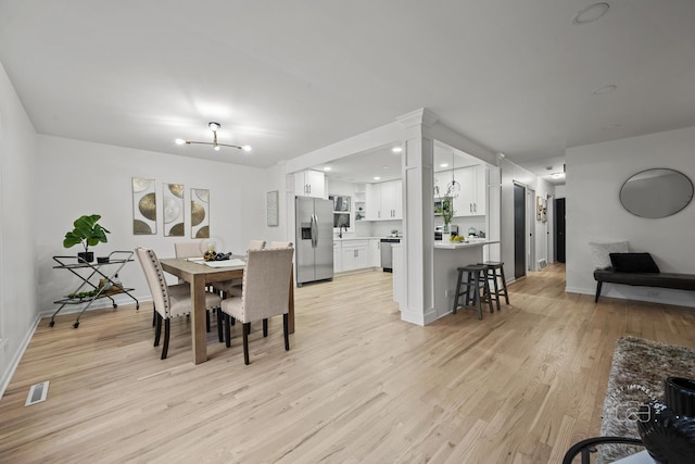 dining room with a notable chandelier and light wood-type flooring