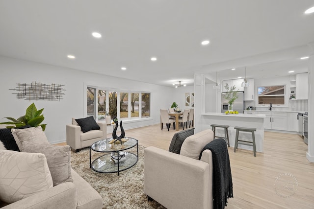 living room featuring light hardwood / wood-style floors and sink