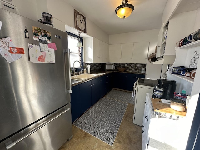 kitchen featuring blue cabinetry, white appliances, white cabinetry, and backsplash