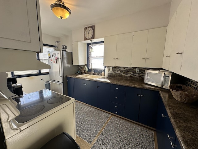 kitchen featuring sink, white cabinets, and blue cabinets