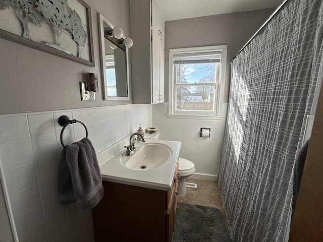 bathroom with vanity, curtained shower, toilet, and tile walls