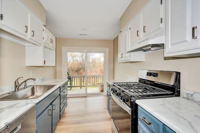 kitchen featuring blue cabinetry, stainless steel appliances, white cabinetry, and sink