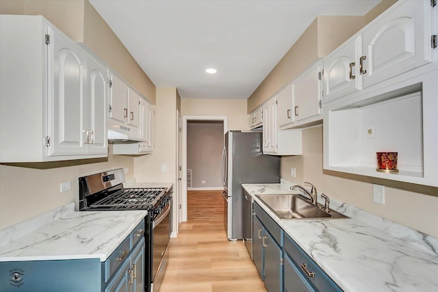 kitchen with appliances with stainless steel finishes, light wood-type flooring, blue cabinets, sink, and white cabinets