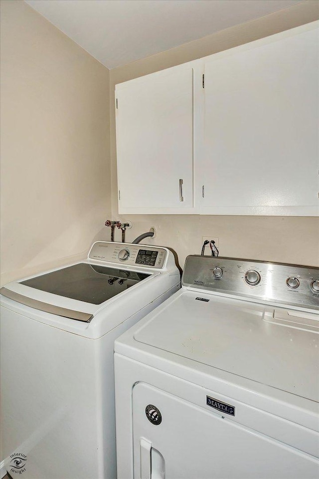 laundry room with cabinets and washing machine and dryer