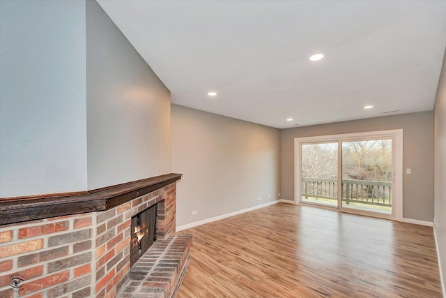 unfurnished living room with a fireplace and light wood-type flooring