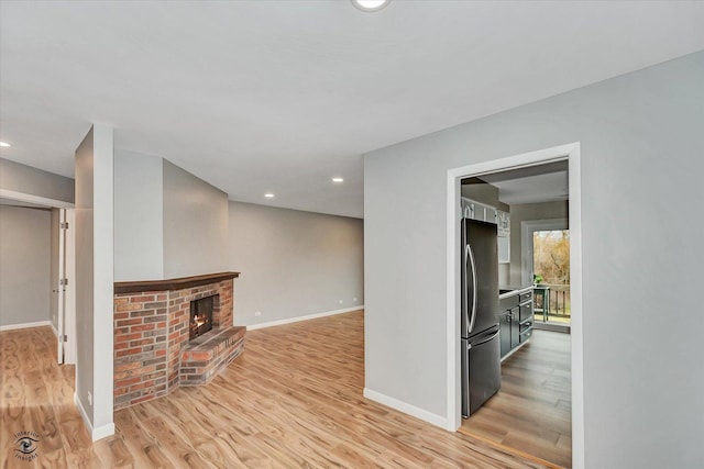 unfurnished living room with light wood-type flooring and a fireplace