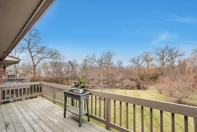 wooden deck featuring a lawn