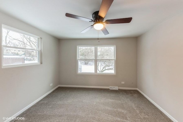 carpeted spare room with ceiling fan