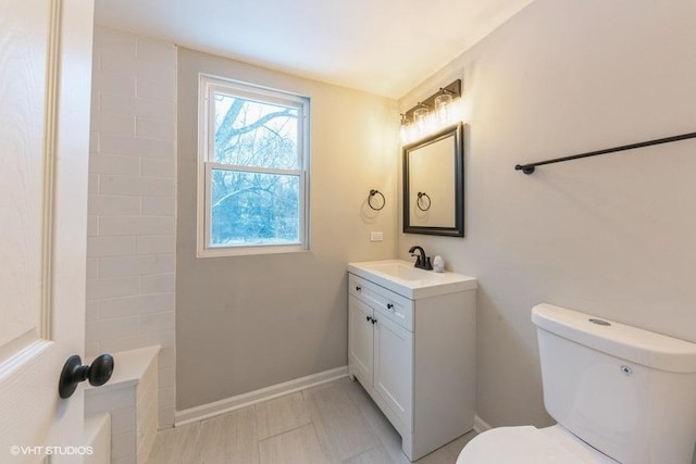 bathroom featuring vanity, toilet, and walk in shower