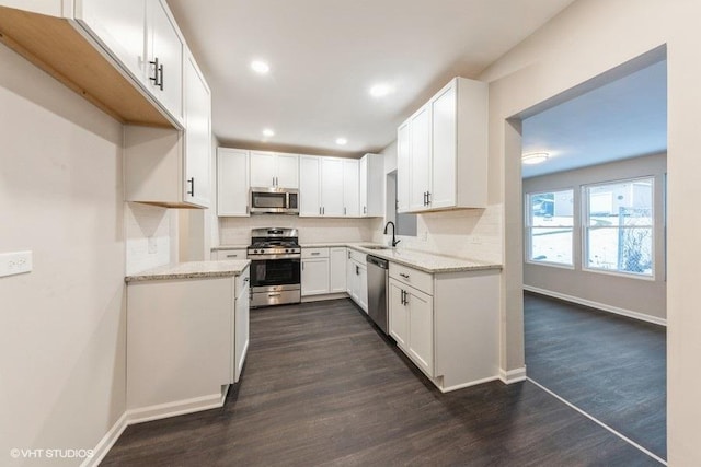 kitchen with dark hardwood / wood-style flooring, white cabinetry, sink, and appliances with stainless steel finishes