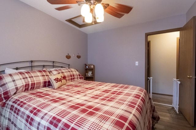 bedroom with ceiling fan, hardwood / wood-style floors, and vaulted ceiling